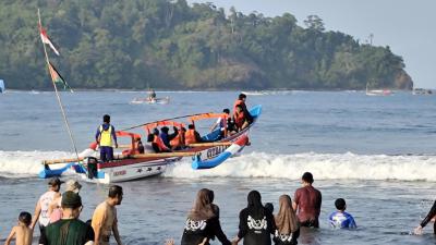 Potret Wisatawan Naik Perahu di Laut Pangandaran